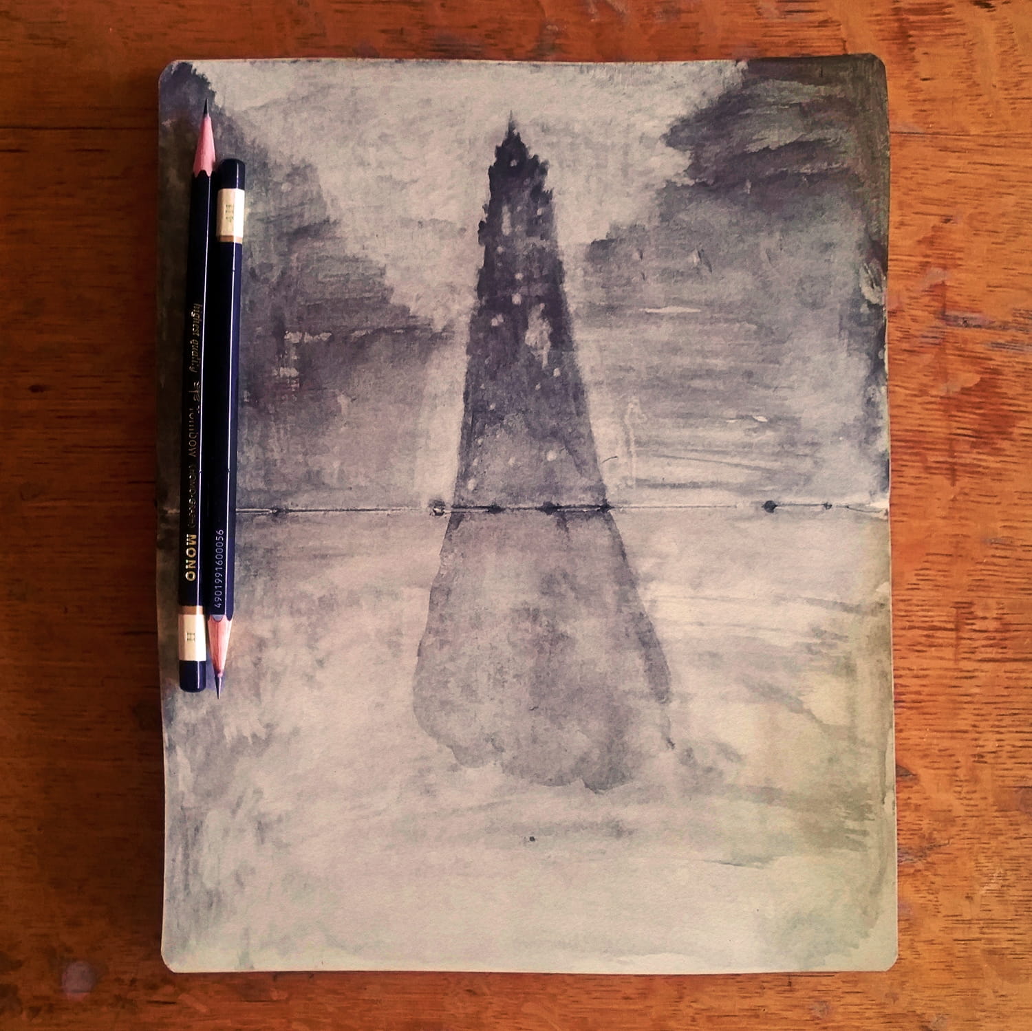 Open sketchbook with two pencils lying across it, with an illustration of a conical tower, seen from a distance, rising lighthouse-like from grey and indistinct terrain.  It has many small windows and is capped by a pointed spire.